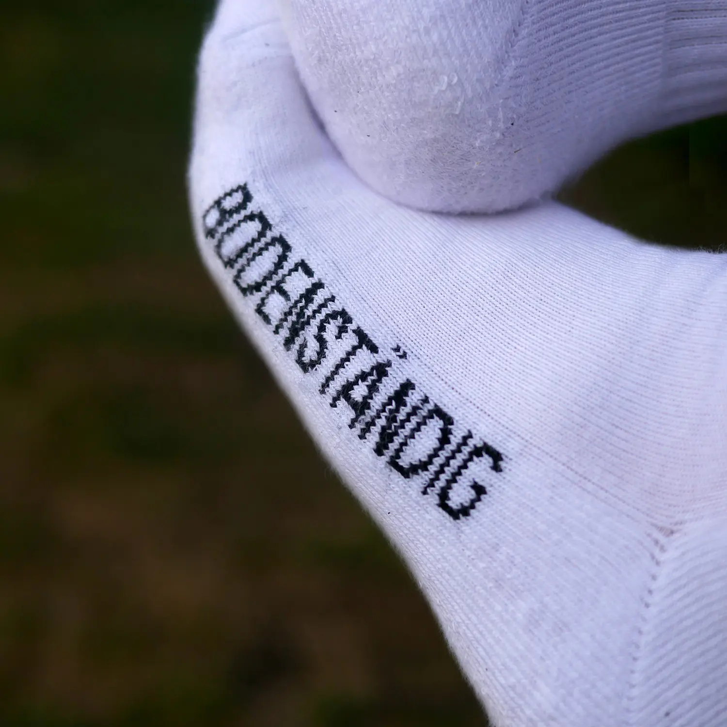 Eine Detailaufnahme Von Den Ols Tennissocken. Dort Steht Bodenständig