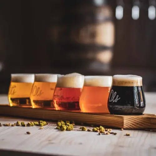 Fünf verschiedene Ols Biere in kleinen Gläsern auf einem Holzbrett