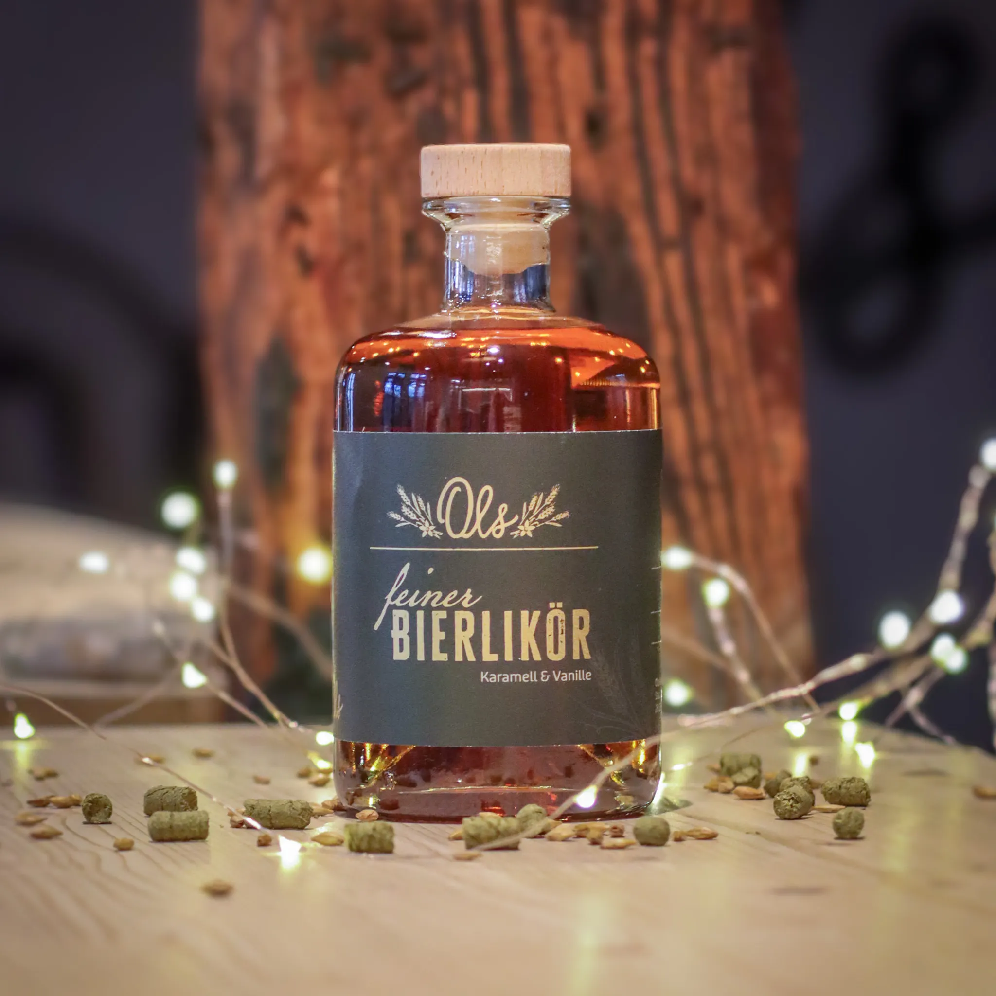 Ols Bierlikör Eine Flasche Ols Bierlikör Auf Einem Holztisch. Dekoriert Mit Einer Lichterkette Und Hopfen